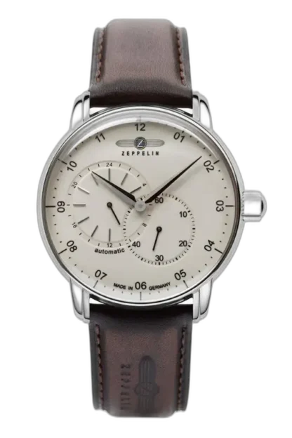 Elegancki zegarek Zeppelin New Captain’s Line 8662-5 Automatic z jasną tarczą, dwoma subtarcza dla czasu 24-godzinnego i sekundnika, zamknięty w stalowej kopercie. Wyposażony w brązowy skórzany pasek z tłoczonym logo Zeppelin, łączący klasyczny design z automatycznym mechanizmem. Idealny wybór dla miłośników precyzyjnych czasomierzy.